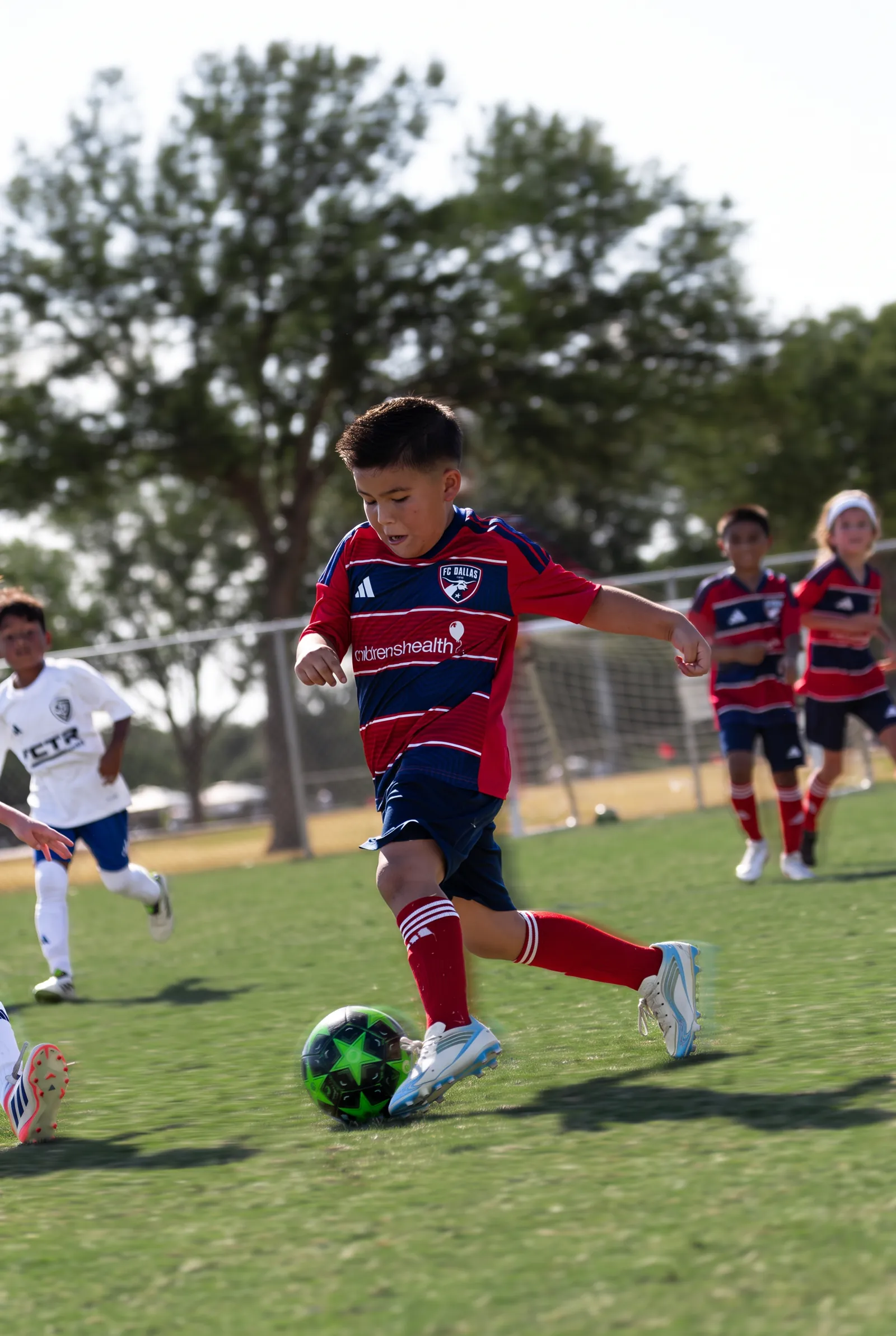 Lee, FC Dallas number 5, dribbling at speed with the ball at his feet
