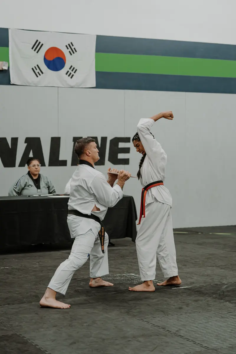 Taekwondo student breaking a board at a belt test in Dallas